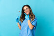 © luismolinero - Woman dentist holding tools over isolated on blue background happy and smiling