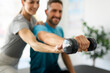 © Louis-Paul Photo - Modern rehabilitation physiotherapy woman worker with man client