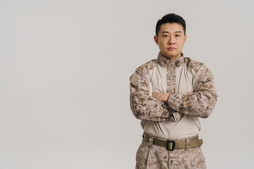 Wall Mural - Asian military man wearing uniform posing and looking at camera