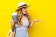 © luismolinero - Young woman goes on vacation to the beach isolated on yellow background with surprise facial expression