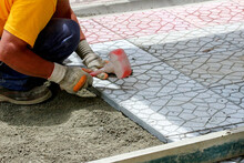 Mason Worker Making Sidewalk Pavement With Concrete Blocks