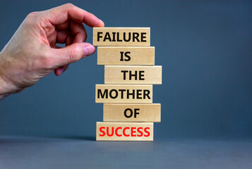 Wall Mural - Failure or success symbol. Wooden blocks with words A failure is the mother of success. Beautiful grey table grey background. Businessman hand. Business, failure or success concept. Copy space.