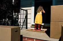 Little Girl In Front Of Home With Moving Boxes