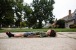 © Maria Manco/Stocksy - boy lays in driveway and watches clouds