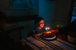 © Maria Manco/Stocksy - little girl blows out candles on cake