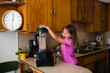© Maria Manco/Stocksy - child pours green smoothie into cups