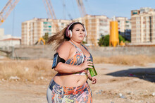 Plus Size Woman Running In An Industrial Area