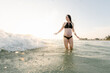 © Alison Winterroth/Stocksy - Pregnant woman about to get hit with wave