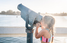 Little Girl Looks Through Tower Viewer Binocular On The Coast 