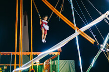 Girl Jumping Above Trampoline At Night
