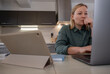© Milles Studio/Stocksy - Thoughtful businesswoman using laptop in kitchen