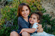 © Erin Brant/Stocksy - Happy young sisters sitting on ice plants