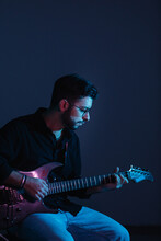 Young Artist Playing Electric Guitar With Blue Background
