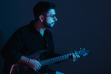 Young Artist Playing Electric Guitar With Blue Background