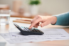 Woman Using Calculator And Paying Bills At Home
