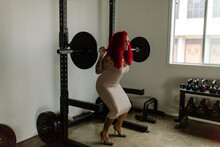 Muscular Redhead In Dress Lifting Weights