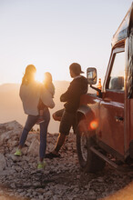 Traveling Family Admiring Sunset In Mountains