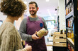 © Javier Díez/Stocksy - Smiling vendor showing organic spices to customer