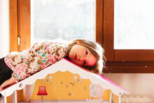 Girl Lying On A Toy House