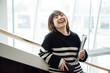 © ZQZ Studio/Stocksy - Portrait of a laughing Chinese girl  on stairs