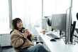 © ZQZ Studio/Stocksy - Young business woman holding coffee cup in office