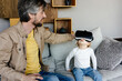 © Sergey Narevskih/Stocksy - Father showing child video in VR goggles