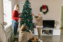 Cheerful Family Decorating Home For Christmas Days