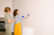 © ByLorena/Stocksy - Colleagues choosing accent wall color at empty house