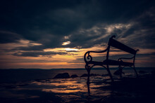 Long Exposure Photo Of A Bench In Sunset At The Sea