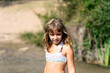 © Albert Martinez/Stocksy - Smiling girl in swimwear near river