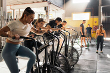 Motivated People Exercising On Cycling Machine In Gym