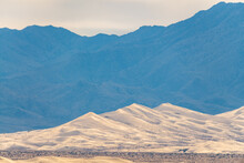 Kelso Sand Dunes In California Seen In Distance In Front Of Towering Mojave Desert Mountains. 