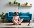 © Elena Kharichkina/Stocksy - Woman meditating at home