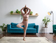 © Elena Kharichkina/Stocksy - A woman practising yoga, meditating and stretching at home