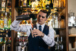 © Pedro Merino/Stocksy - Professional bartender preparing cocktail in pub