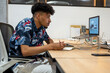 © Bisual Studio/Stocksy - Black employee working on graphic tablet and laptop