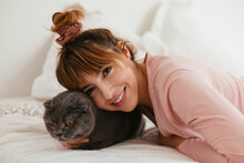 Delighted Woman With Fluffy Cat On Bed