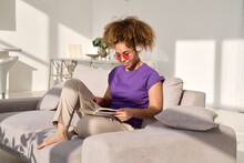 Woman Reading Book On Sofa