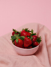 Organic Strawberries With Green Leaves On Pink Background