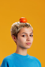 Female Teenager With Orange On Head