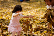 Child Playing With Golden Leaves