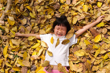 Child Playing With Golden Leaves