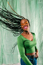 Woman With Creative Colorful Makeup Moving Her Braided Hair Smiling