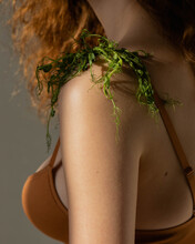 Close-up Of Woman's Shoulder With Greenery