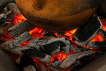 Closeup Of A Wooden Pot Over Burning Coals