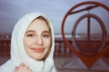 Portrait Of Woman In White Hood Next To A Here You Are Symbol 