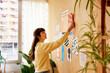 © ALTO IMAGES/Stocksy - Young freelancer making collage on wall