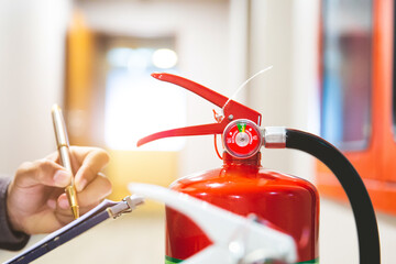 Wall Mural - Fire extinguisher has engineer inspection checking pressure gauges of fire extinguishers to prepare fire equipment for protection prevent emergency and safety rescue and alarm system training concept.