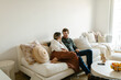 © STUDIO TAURUS/Stocksy - Middle age happy couple sitting on the couch at home