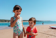 Little Girls Eating Ice Cream On Summer Beach 